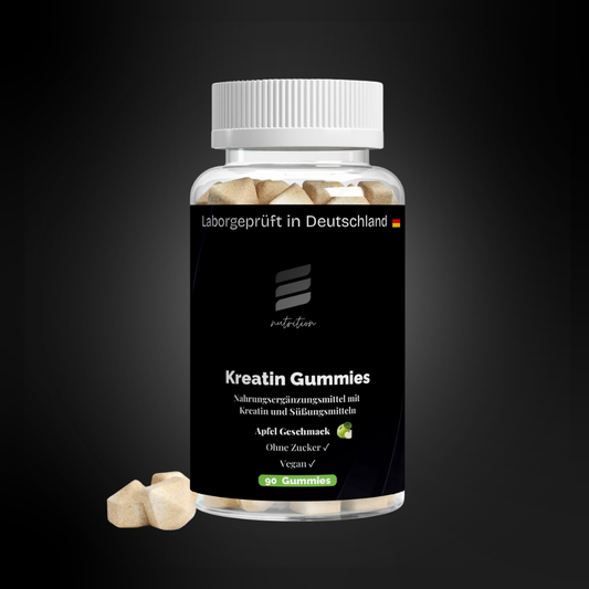 Transparente Dose mit schwarzen Etikett für Kreatin-Gummies im Apfelgeschmack, Aufdruck „Laborgeprüft in Deutschland“, Markenlogo, Produktname sowie Hinweise wie ohne Zucker und vegan; 90 Gummies sichtbar im Inneren, einige Gummies liegen daneben.